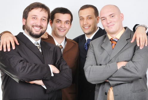 Group of young businessmen together on light background