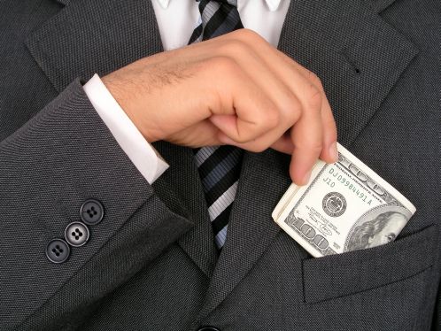 businessman putting money into pocket