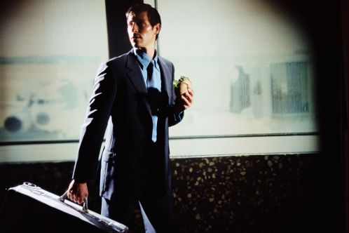 Businessman with hamburger and luggage